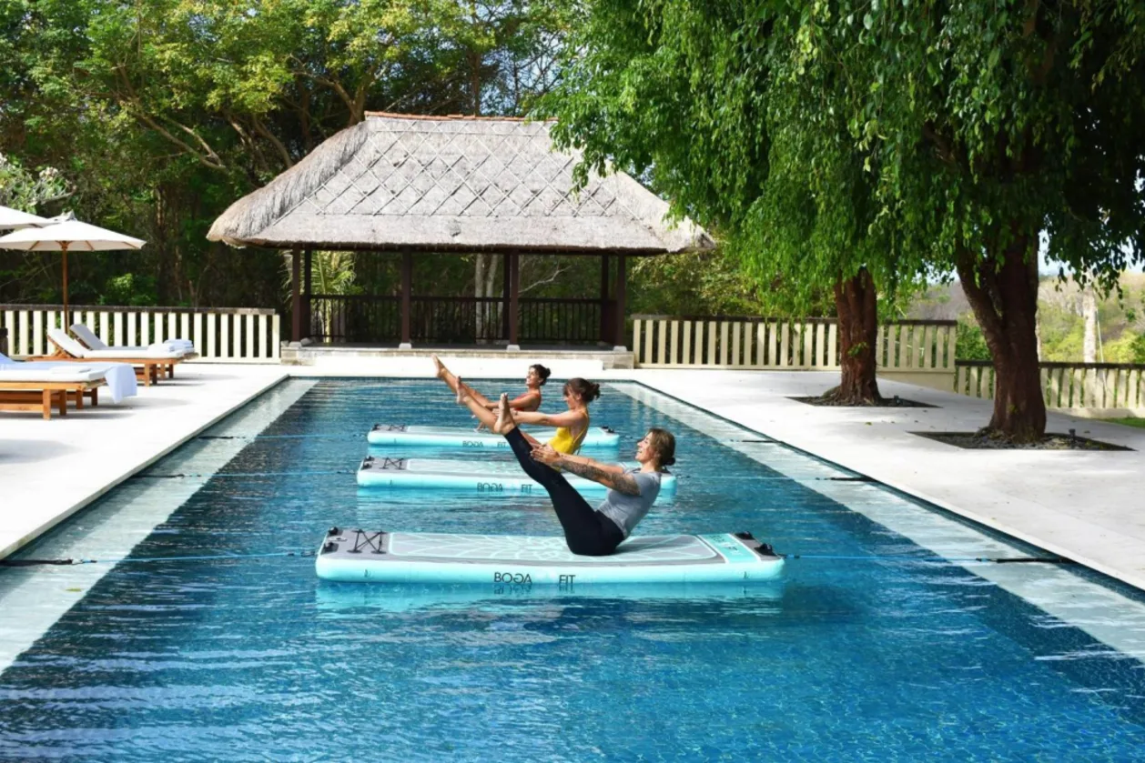 Outdoor pool yoga at REVĪVŌ Wellness Bali retreat